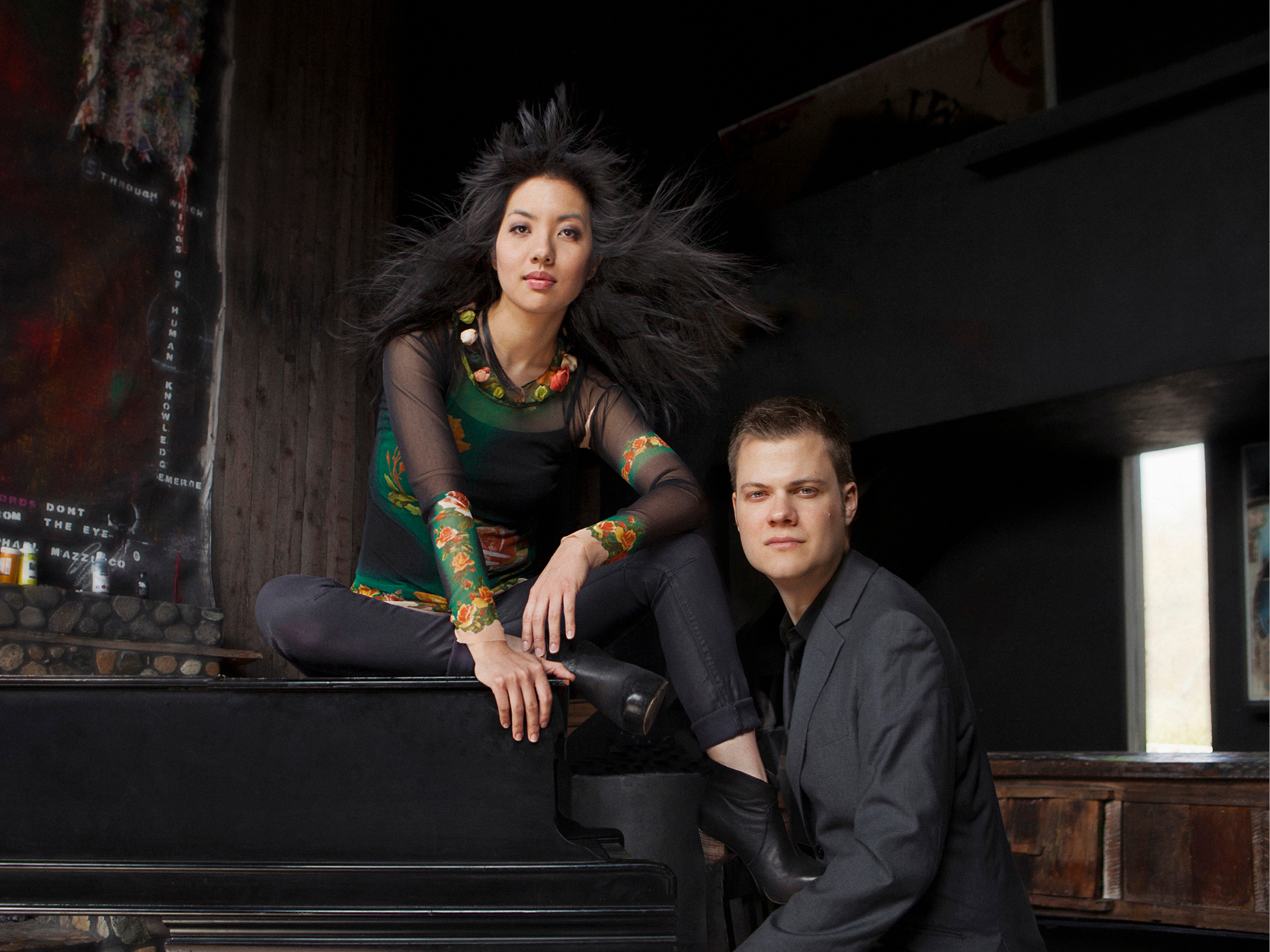 A women and a man sitting on a piano